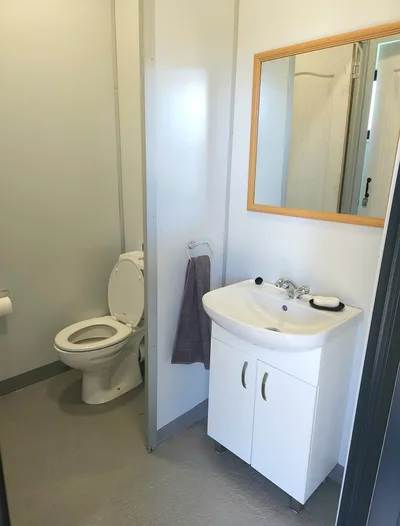 Staff bathroom with toilet, vanity basin and mirror