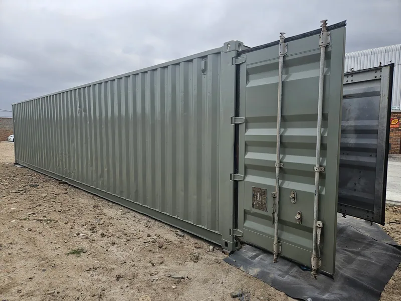 Long pale green 12m container on plastic sheeting with the end doors closed