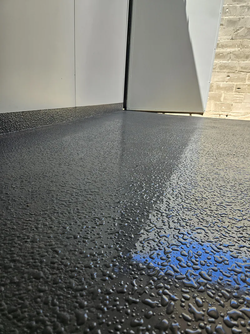 Freshly applied non-slip grey floor coating inside a container kitchen