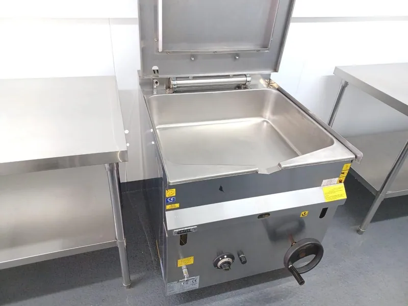 Stainless steel tilting bratt pan and worktop installed in a container kitchen
