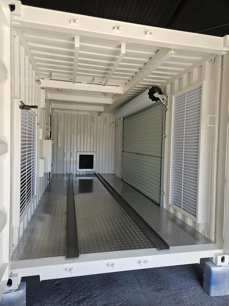 Interior of a white-lined container with a roller shutter opening and a recessed floor channel